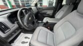 Front interior of a Chevrolet SUV with grey cloth seats, steering wheel, and center console visible.