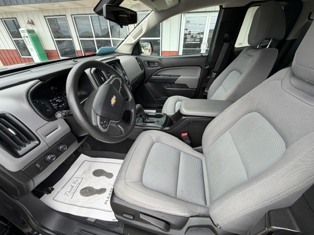 Front interior of a Chevrolet SUV with grey cloth seats, steering wheel, and center console visible.