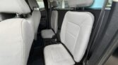 Gray fabric car interior with front row seats and rear bench visible, headrests, and cup holders between the seats.