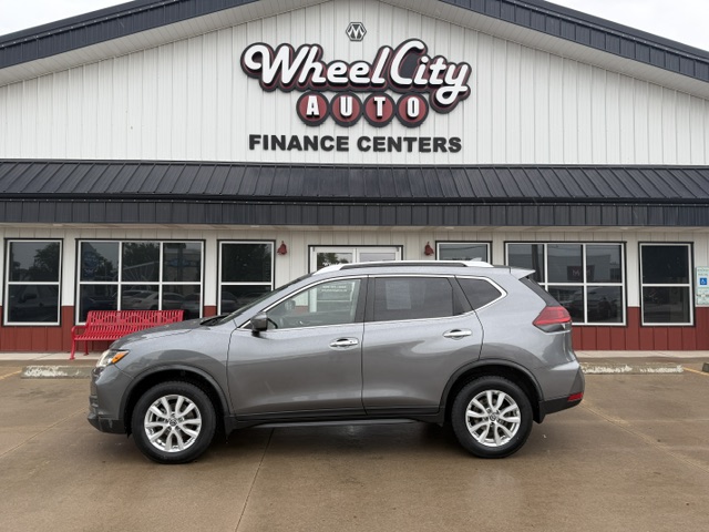 Gray SUV parked in front of Wheel City Auto Finance Centers storefront sign.