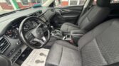 Interior view of a modern car: driver and front passenger seats, steering wheel, and center console with gear shifter.