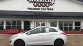 Silver hatchback car parked in front of Wheel City Auto Finance Centers storefront