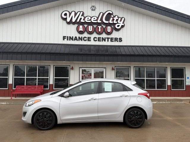 Silver hatchback car parked in front of Wheel City Auto Finance Centers storefront
