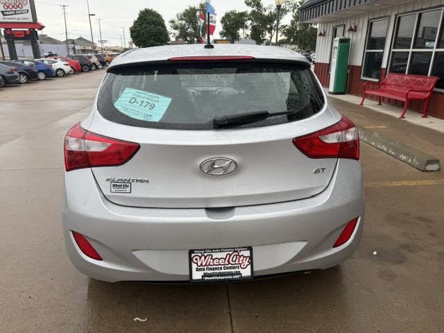 Rear view of a silver Hyundai Elantra GT parked at a dealership; blue sale sticker on the rear window and Wheel City Auto Finance Centers license plate frame visible.