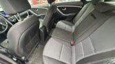 Back seat area of a black sedan with fabric upholstery and center console, view from rear passenger side door