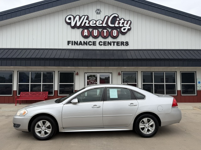 Silver sedan parked in front of Wheel City Auto Finance Centers storefront.