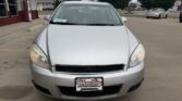 Front view of a silver sedan in a parking lot, dealership plate reads Wheel City Auto Finance Centers.