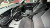 Front interior of a Chevrolet sedan showing steering wheel, driver and passenger seats, center console, and dashboard features.