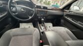 Interior of a Chevrolet car viewed from the back seat, showing the steering wheel, dashboard, and center console with wood trim.