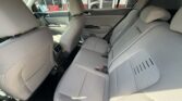 Interior of a gray fabric car showing the rear bench and front seats from the back passenger side Window reflections and door panels visible for context.
