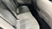 Rear seating area of a car with light gray leather upholstery, shown with seat belts and door panel.