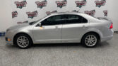 Silver sedan parked in a showroom with a Wheel City Auto Finance Centers banner backdrop