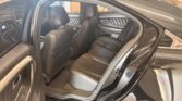 Open rear passenger door showing black leather SUV interior with rear bench seat and front seats, door panel with stitching and vents.