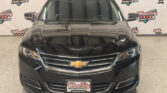 Front view of a black Chevrolet SUV in a showroom with Wheel City Auto Finance Centers branding in the background.