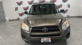 Front view of a tan Toyota SUV indoors, with a Wheel City Auto Finance Centers backdrop overhead.