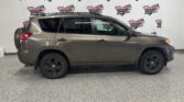 Side view of a gray SUV in a showroom with a 'Wheel City Auto Finance Centers' banner in the background