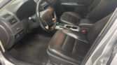 Black leather driver and front passenger seats in a car with steering wheel and center console visible.