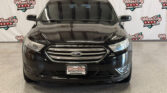 Front view of a black Ford SUV in a dealership showroom with Wheel City Auto Finance Centers banners in the background.