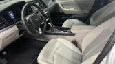 Interior of a modern car showing the driver and passenger seats, steering wheel, center console, and door panel from the passenger side view