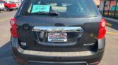 Rear view of a black Chevrolet Equinox in a dealership lot, with a teal D-1467 dealer sign on the rear window and Wheel City license plate frame.