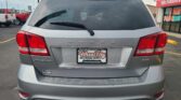 Rear view of a silver Dodge Journey SUV in a dealership lot, license plate frame reading Wheel City Auto Finance Centers.