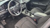 Interior of a modern car showing the driver's seat, steering wheel, center console, and front passenger seat.