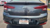 Rear view of a dark gray Hyundai Elantra in a parking lot, with a Wheel City license-frame visible on the bumper.