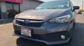 Front-left view of a gray Subaru SUV in a car dealership lot with Wheel City Auto Finance Centers plate frame visible on the bumper