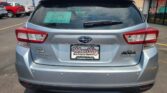 Rear view of a silver Subaru SUV with roof rack, dealership paper in rear window showing D-179 and Wheel City Auto Finance Centers.