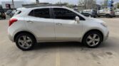 White crossover SUV parked in a lot, side view with four doors, tinted windows, and alloy wheels.