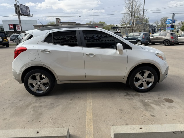 White crossover SUV parked in a lot, side view with four doors, tinted windows, and alloy wheels.