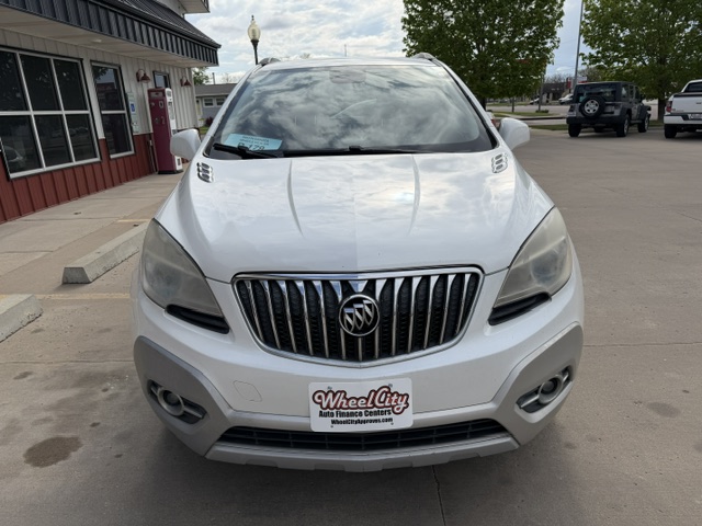 Front view of a white Buick SUV parked in a dealership lot, with a Wheel City license plate frame on the front bumper.