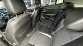Back seat area of a black leather sedan with two front seats and visible headrests; door panels and center console seen through the rear window region