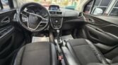 Interior view of a Buick car cabin with black leather seats, steering wheel, center console with touchscreen, gear shifter, and dashboard controls; photo taken from the front passenger seat showing the driver and passenger sides.