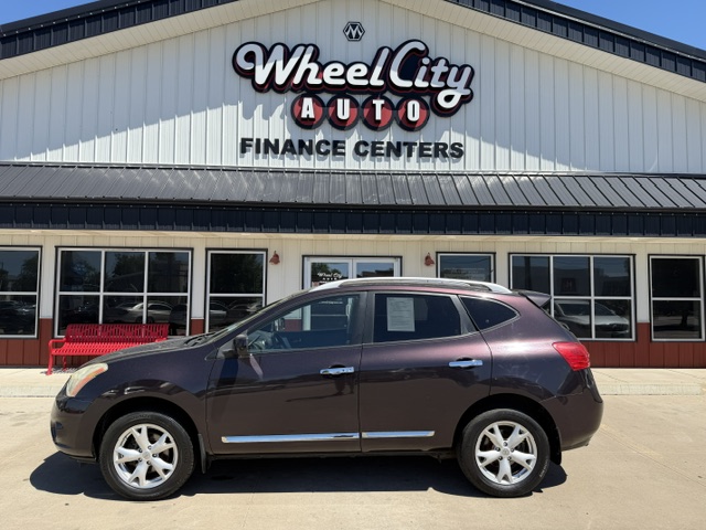 Brown SUV parked in front of Wheel City Auto Finance Centers storefront with large windows and sign above.