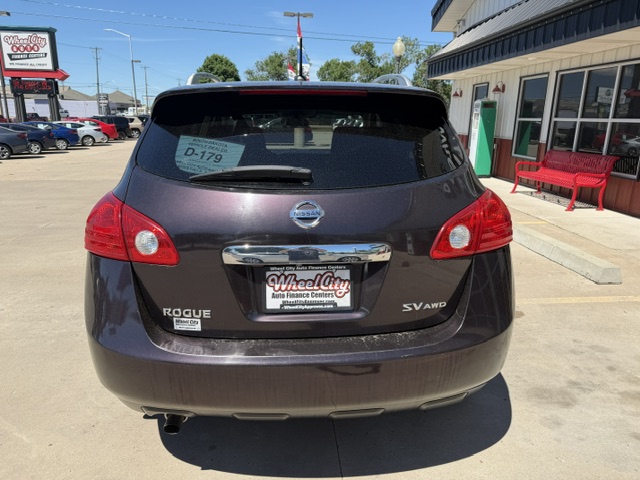 Rear view of a dark gray Nissan Rogue SV AWD parked in a dealership lot, with a Wheel City Auto Finance Centers plate frame visible on the bumper.