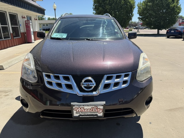 Front view of a maroon Nissan SUV in a dealership lot, Wheel City license plate frame visible on the bumper.