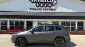 Gray SUV parked in front of Wheel City Auto Finance Centers storefront.