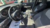 Interior of a Jeep showing the steering wheel, driver's seat, center console with gear shifter, and front passenger seat in a sunlit car
