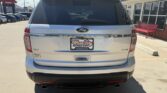 Rear of a white Ford SUV with XLT badge, parked in a dealership lot; Wheel City license plate frame.