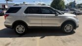 Side view of a silver mid-size SUV parked in a parking lot on a sunny day.