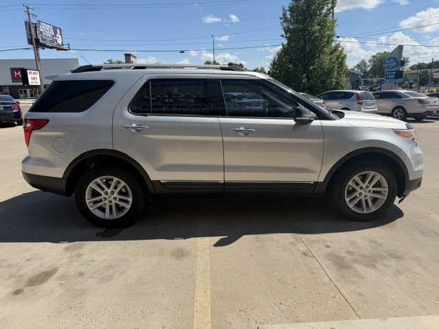 Side view of a silver mid-size SUV parked in a parking lot on a sunny day.
