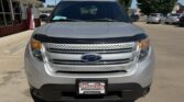 Front view of a silver Ford SUV parked in a dealership lot, with a Wheel City license plate frame visible on the bumper.