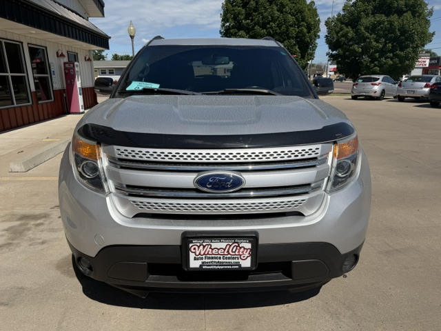 Front view of a silver Ford SUV parked in a dealership lot, with a Wheel City license plate frame visible on the bumper.