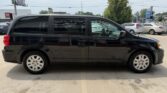 Black minivan parked in a parking lot, shown in profile with sliding side door and tinted windows.