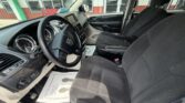 Interior of a Dodge SUV: front seats, steering wheel, dashboard, and center console visible from the driver's side door