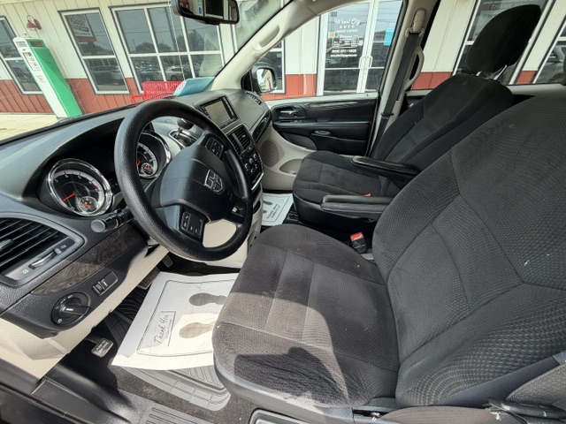 Interior of a Dodge SUV: front seats, steering wheel, dashboard, and center console visible from the driver's side door