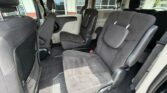 Interior of a gray minivan showing two middle-row captain's chairs and a folded third-row seat, viewed from the rear.