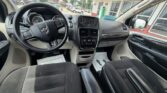 Front interior of a vehicle showing steering wheel, dashboard, center console with touchscreen, and front seats.