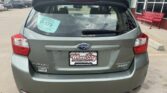 Rear view of a gray Subaru Impreza hatchback at a dealership, with a Wheel City Auto Finance Centers license plate frame and a D-179 window sticker on the rear window.